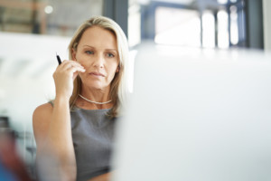 Mature businesswoman using a laptop in office.